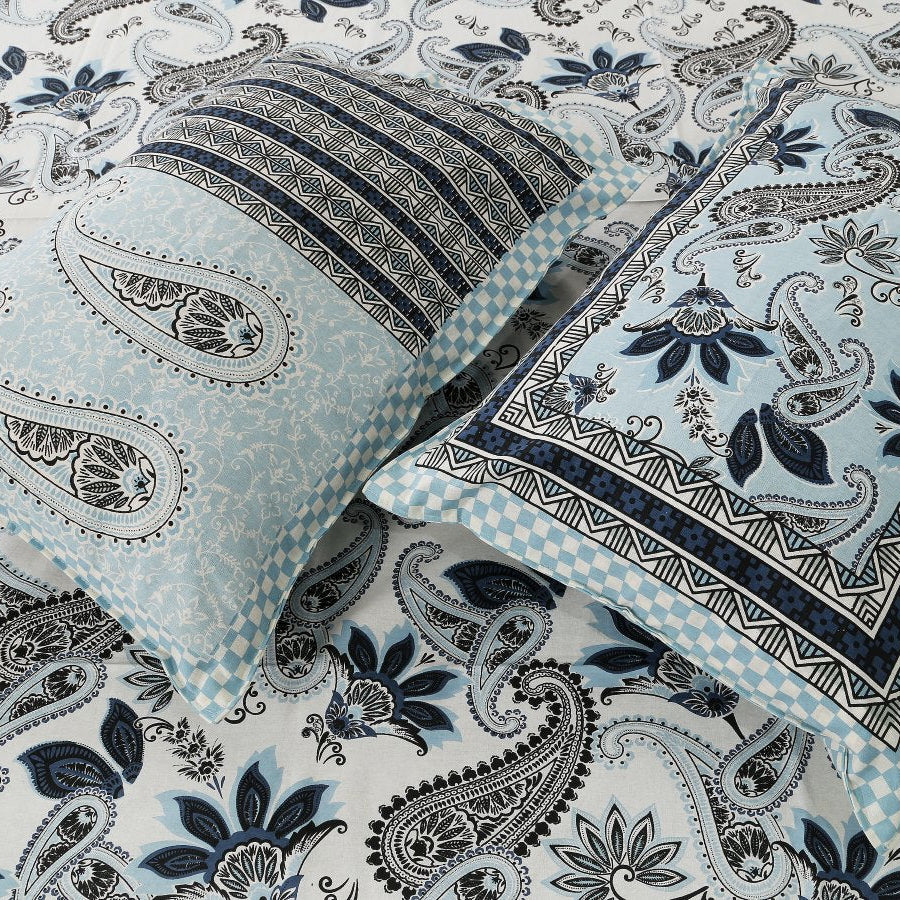 Paisley patterned fabric with a pillow and blanket on top