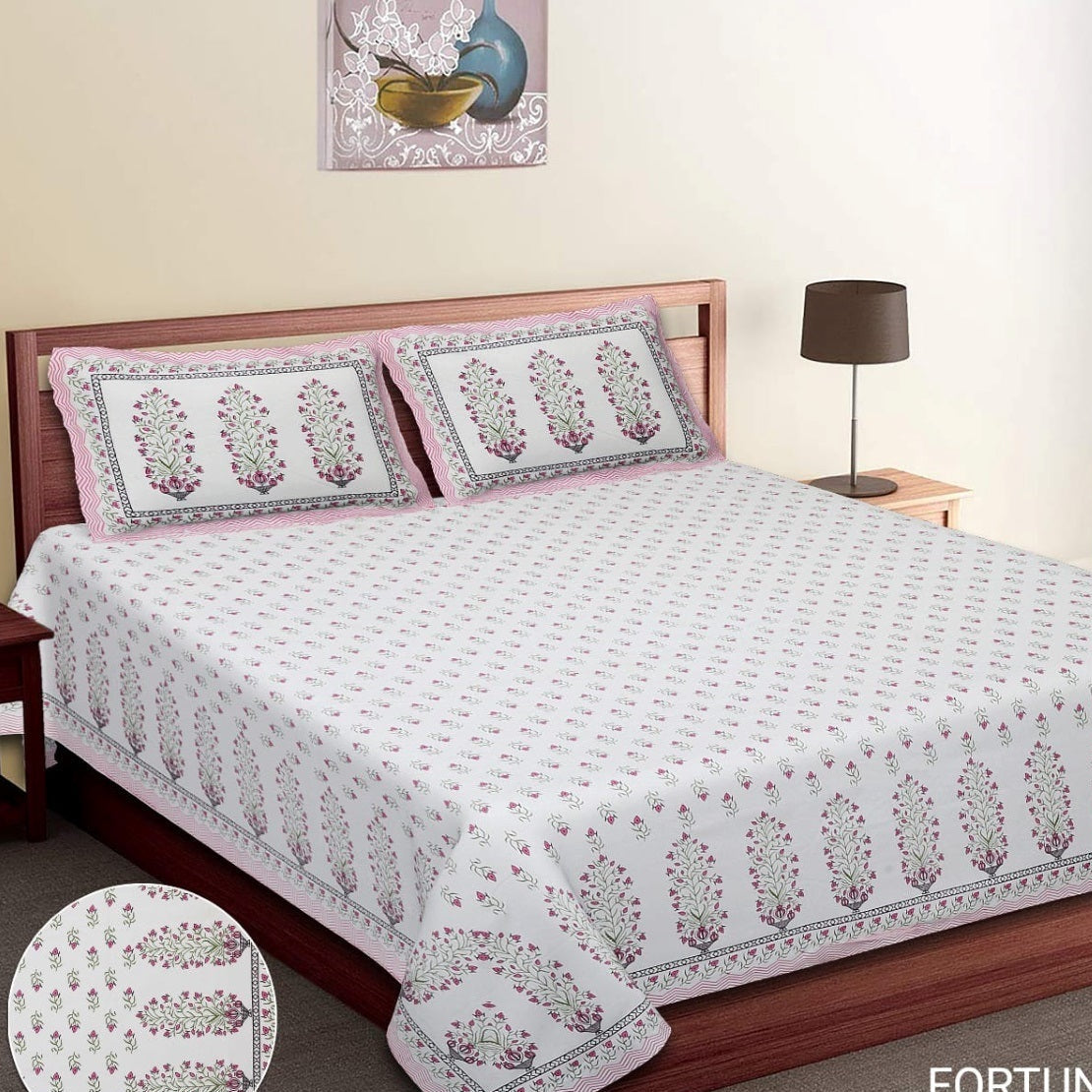 Bed with floral patterned bedspread and pillows in a bedroom setting. RESTEZZY