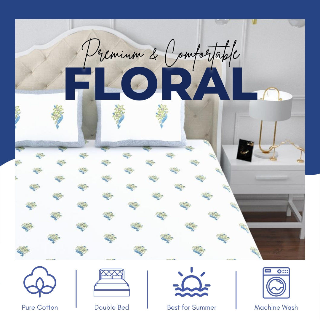 Floral patterned bed sheets on a bed with a nightstand in a bedroom setting.