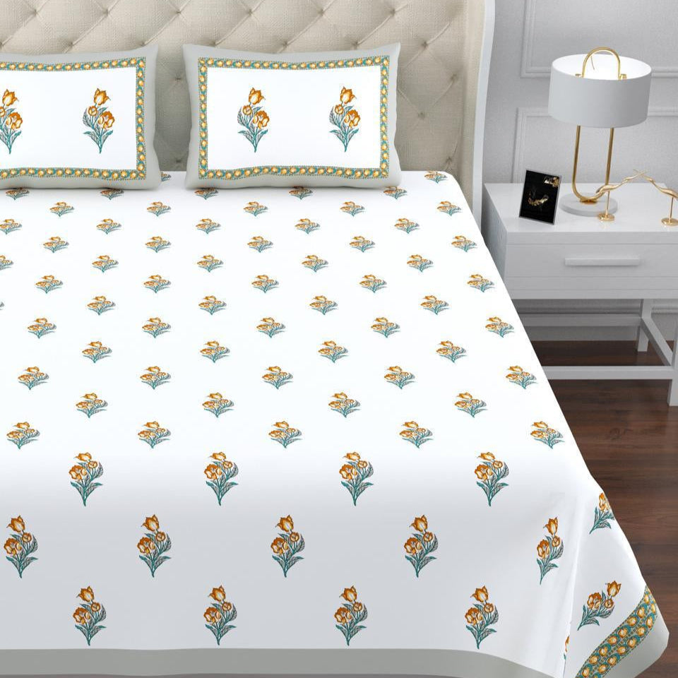 Floral patterned bedspread on a bed with matching pillows in a bedroom setting. restezzy