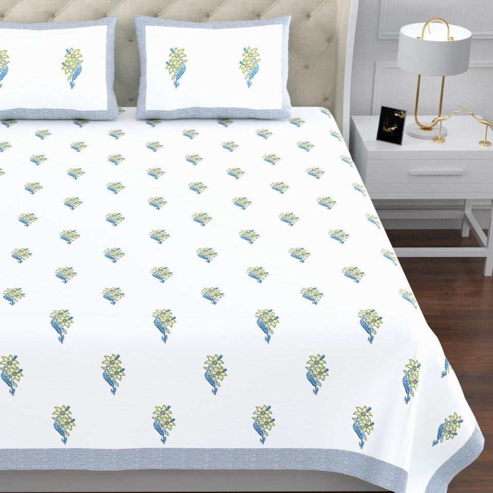 Bed with floral patterned bedspread and matching pillows in a bedroom setting. restezzy