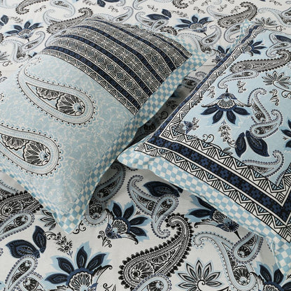 Paisley patterned fabric with a pillow and blanket on top